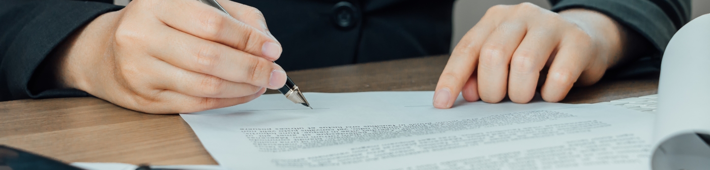 close-up-businesswoman-signing-terms-agreement-document-her-desk
